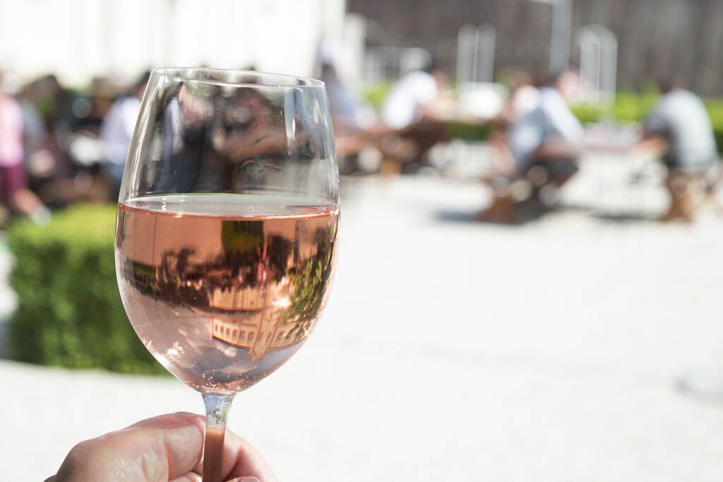 A close-up of a hand holding a glass of rosé.