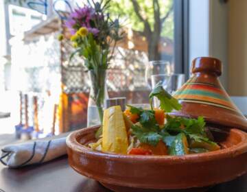 A view of a bright, colorful vegetable tajine dish on a table.