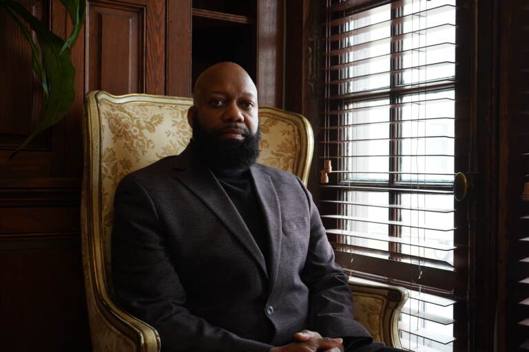 Ed Brown poses for a photo while sitting in a chair