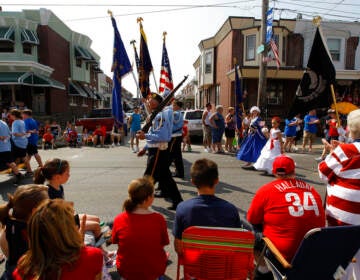 People watch veterans march past them in a Memorial Day parade.