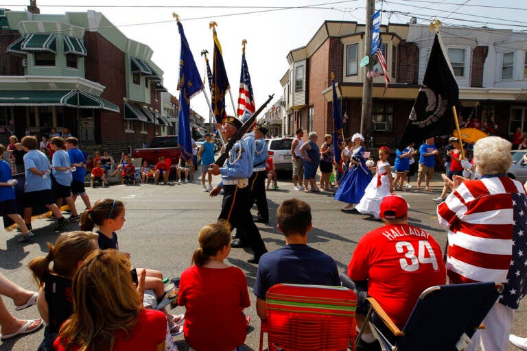 People watch veterans march past them in a Memorial Day parade.