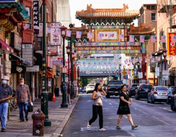 Pedestrians cross 10th Street in the Chinatown neighborhood of Philadelphia