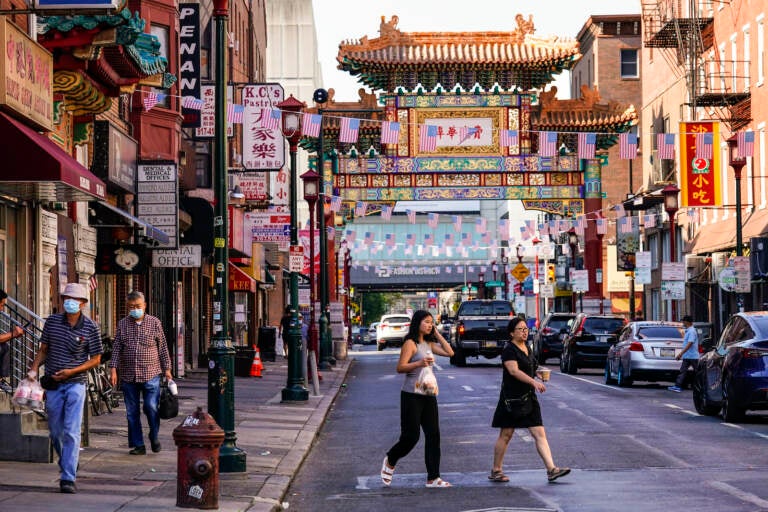 Pedestrians cross 10th Street in the Chinatown neighborhood of Philadelphia