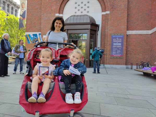 Julia Riskowitz stands with her daughters Amelia and Madeline, seated in a stroller, outside their polling statiomn