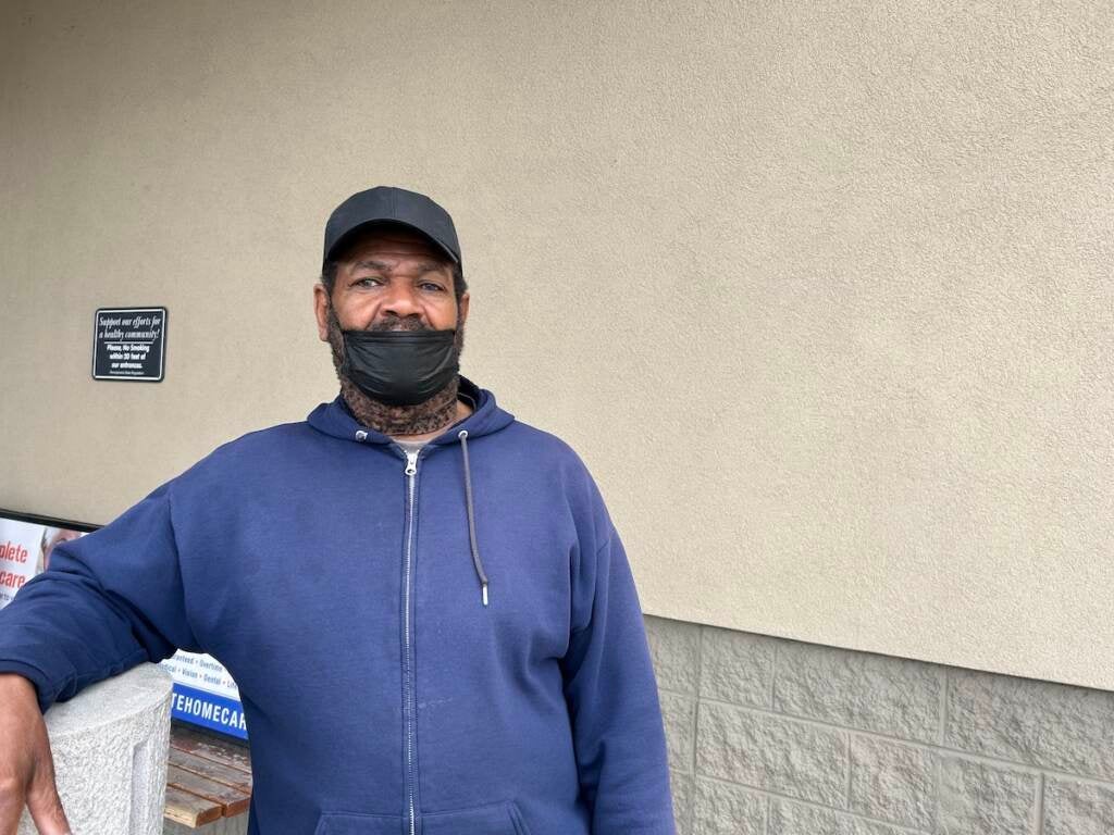 Erik Davis poses for a photo outside of a supermarket.