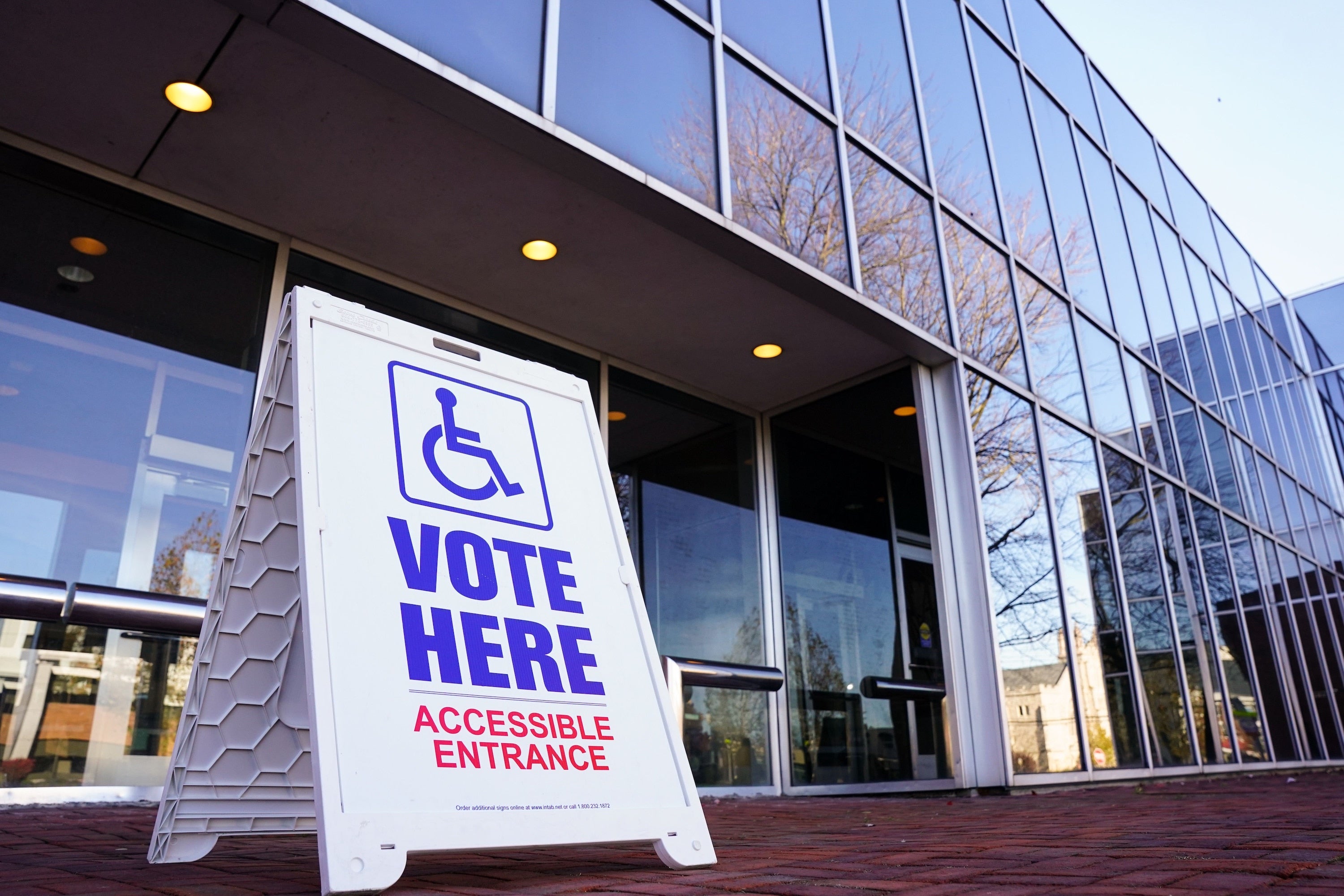 A 'vote here' sign outside of a polling place.