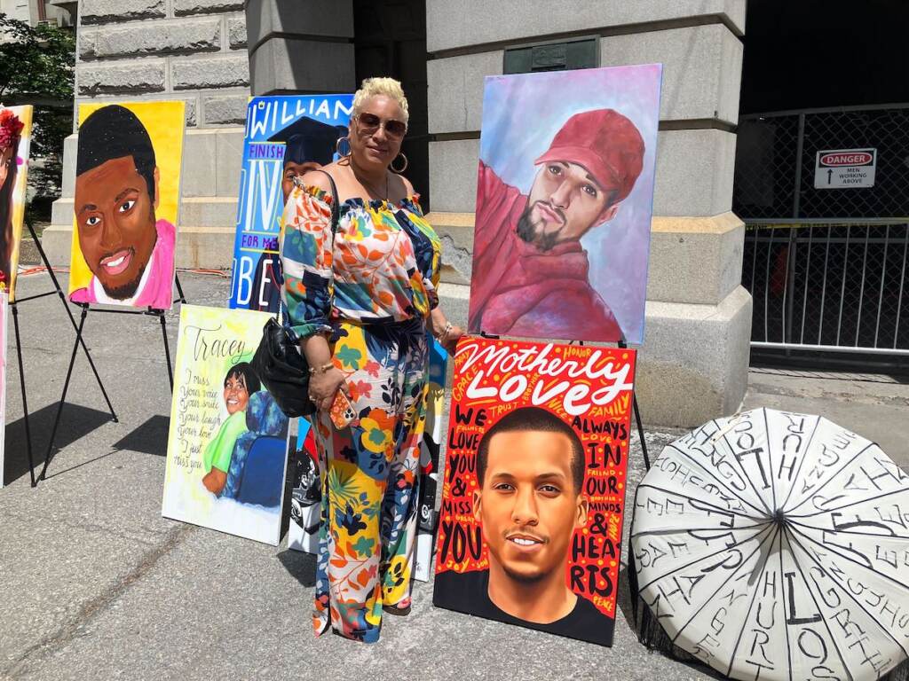 Crystal Arthur poses next to a painting of her son.