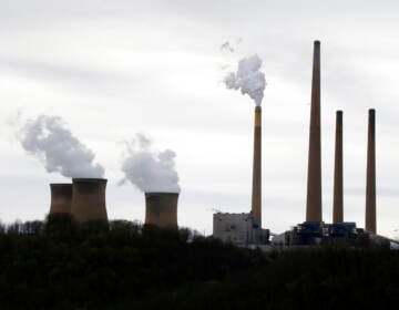 Smoke rises from the stacks of a power plant.