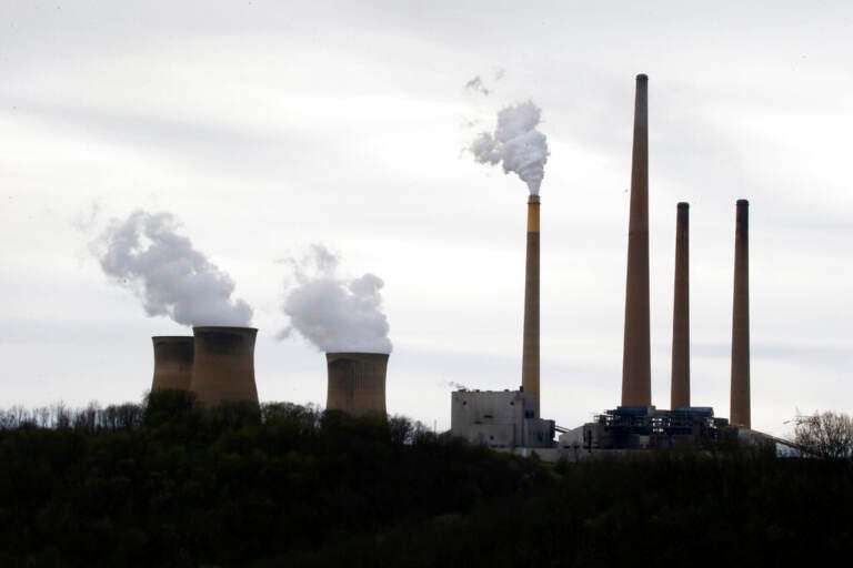 Smoke rises from the stacks of a power plant.