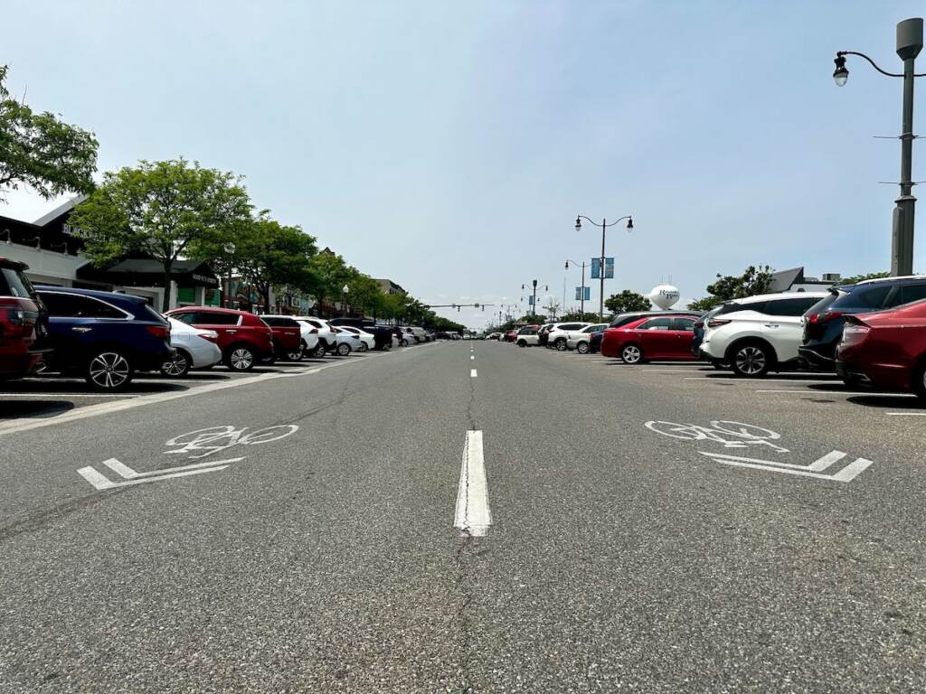 Cars are visible in a parking lot.