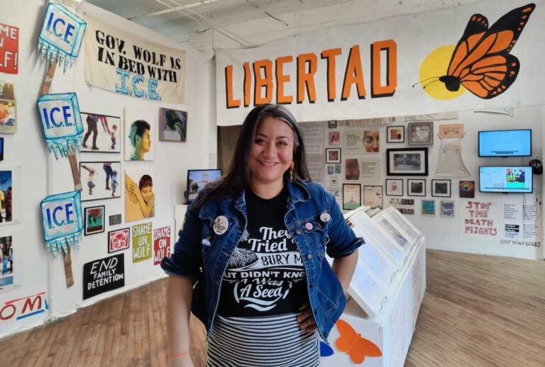 Jasmine Rivera stands in the middle of an art exhibition space.