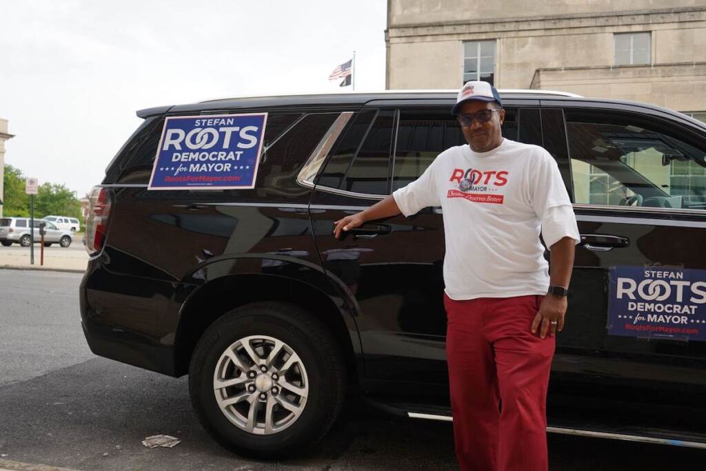 Stefan Roots stands in front of a car.