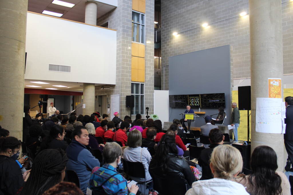 A crowd of people look on at an event.