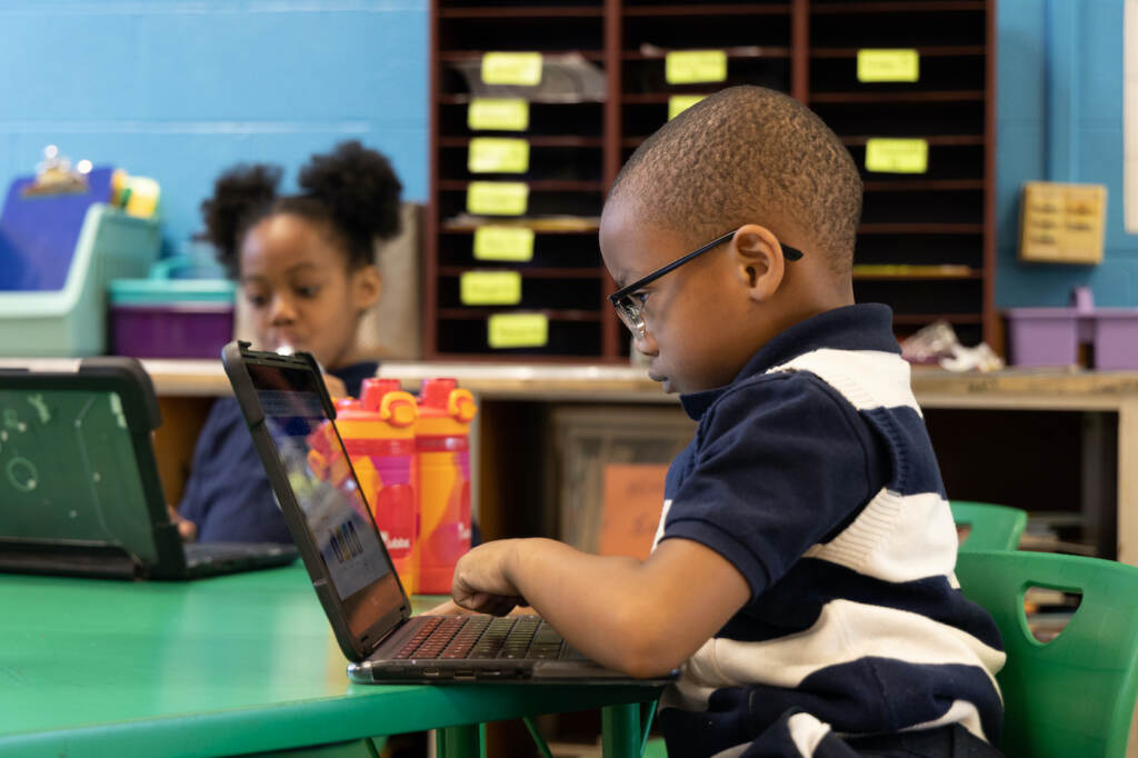 A child working on a computer in a classroom