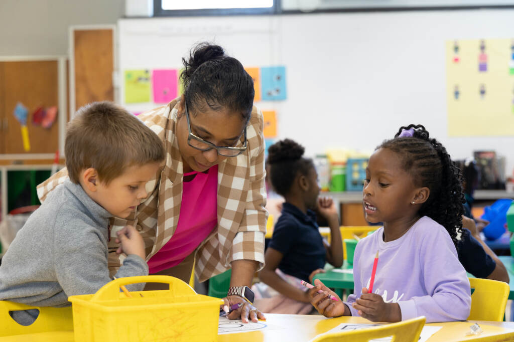 Nicole Miller working with 2 students in her classroom