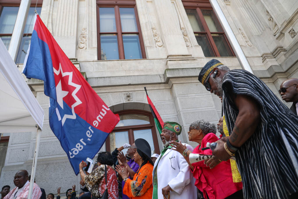 people watch as the flag gets raised.