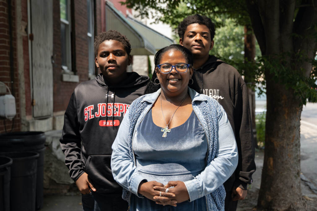 Sheila Armstrong posing with a photo with her two sons