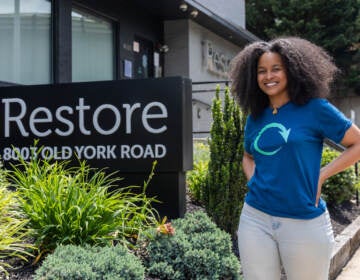 Lyndsay Alston poses for a photo next to a sign that reads 