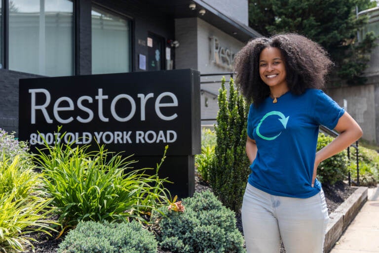 Lyndsay Alston poses for a photo next to a sign that reads 