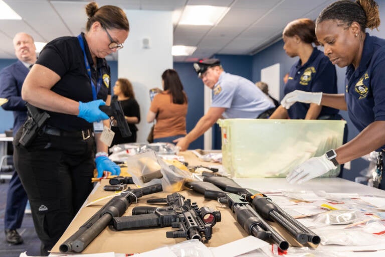 Police officer handling confiscated guns.