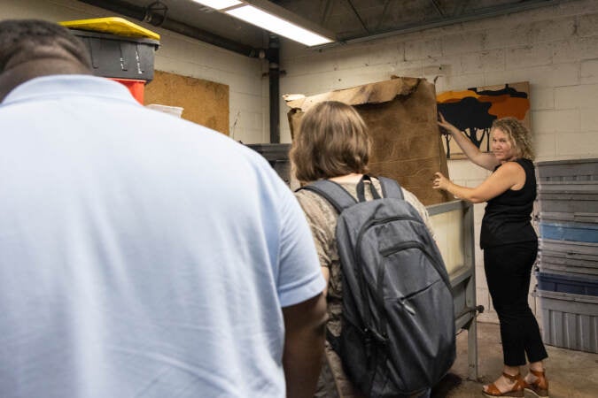 Jen Mastalerz demonstrates a worm bin to visitors to the compost facility she co-owns.