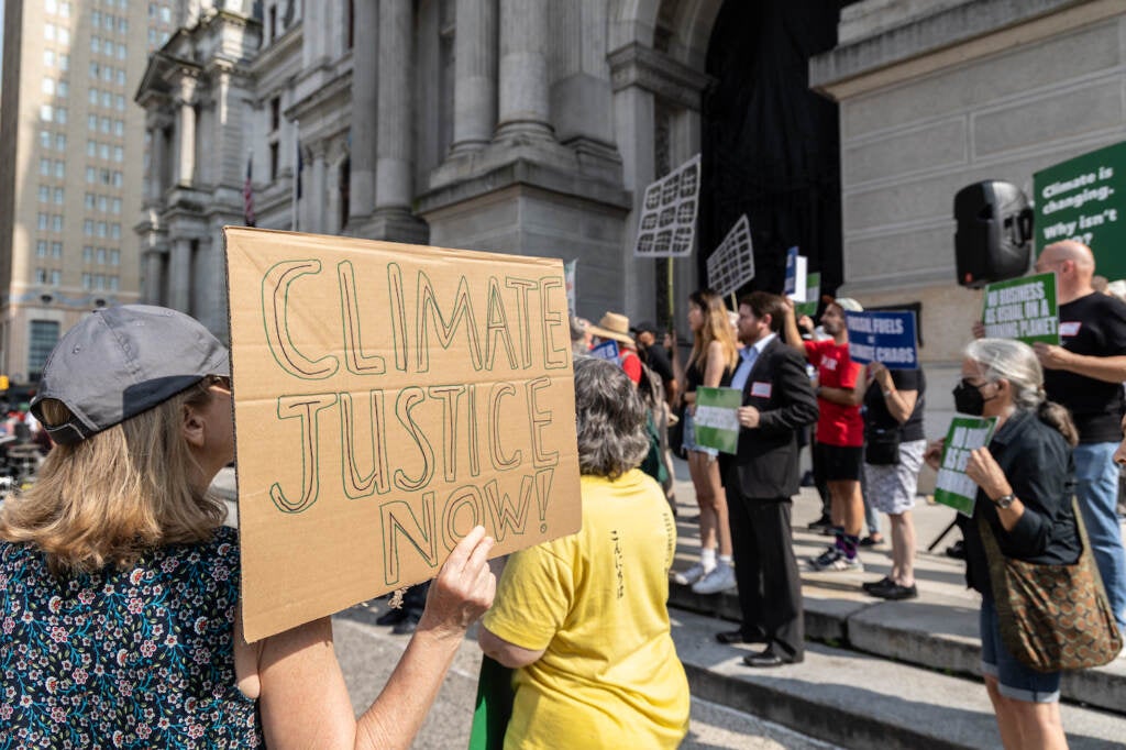 A protester holds a sign reading 'Climate Justice Now!'