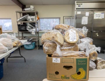 Many bags of bread sit on a table in the food bank.