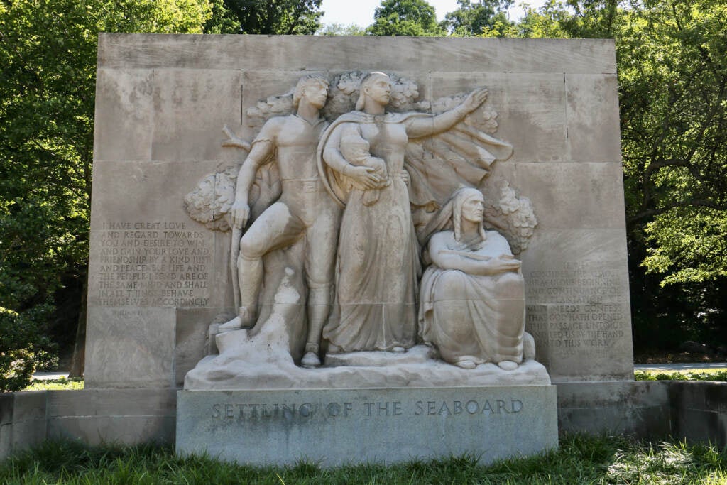 Sculpted figures are visible, with trees behind them.