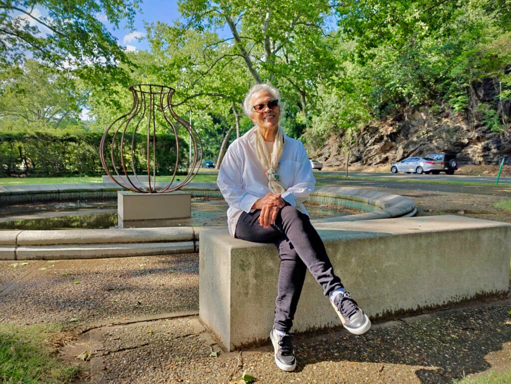 Maren Hassinger poses for a photo in front of one of her sculptures.