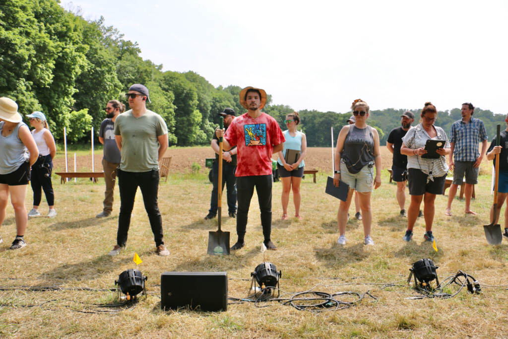 Members of a choir stand in an open field.