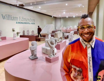 James Claiborne poses in front of the gallery at the Barnes Foundation where William Edmondson's sculptures are displayed.