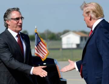 President Donald Trump reaches out to shake hands with North Dakota Gov. Doug Burgum, and his wife Kathryn Helgaas Burgum after arriving at Hector International Airport in Fargo, N.D., Friday, Sept. 7, 2018. Trump is in Fargo to speak at a fundraiser