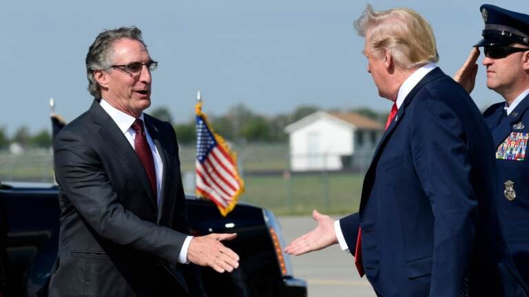 President Donald Trump reaches out to shake hands with North Dakota Gov. Doug Burgum, and his wife Kathryn Helgaas Burgum after arriving at Hector International Airport in Fargo, N.D., Friday, Sept. 7, 2018. Trump is in Fargo to speak at a fundraiser