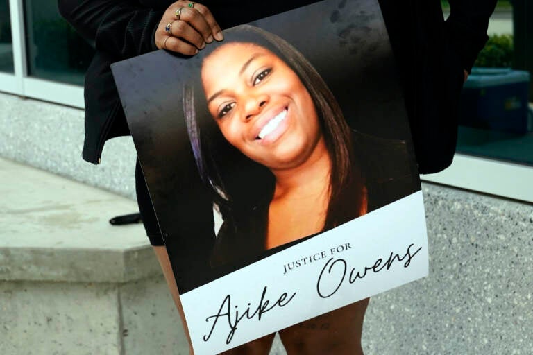 A protester, holds a poster of Ajike Owens at the Marion County Courthouse, Tuesday, June 6, 2023, in Ocala, demanding the arrest of a woman who shot and killed Owens, a 35-year-old mother of four, last Friday night, June 2. Authorities came under intense pressure Tuesday to bring charges against a white woman who killed Owens, a Black neighbor, on her front doorstep, as they navigated Florida’s divisive stand your ground law that provides considerable leeway to the suspect in making a claim of self defense