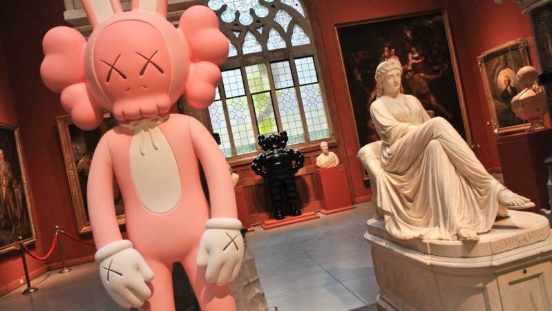 One of KAWS' Acomplices and Chum  juxtaposed with PAFA's more historic work at KAWS @ PAFA. (Kimberly Paynter/WHYY)