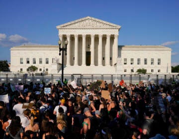 Protesters are visible on the street in front of the U.S. Supreme Court building.