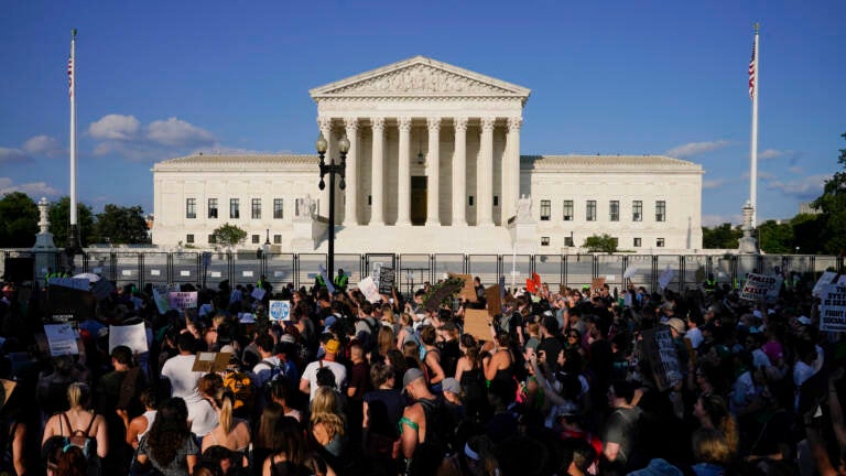 Protesters are visible on the street in front of the U.S. Supreme Court building.