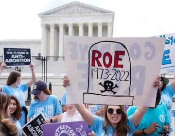 A person holds up a protest sign outside the U.S. Supreme Court.