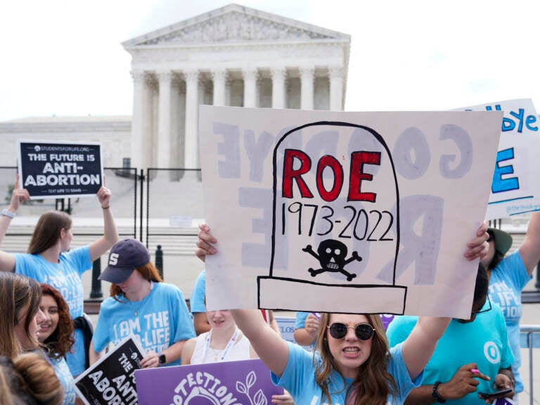 A person holds up a protest sign outside the U.S. Supreme Court.