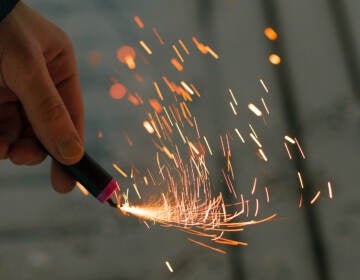 Man holds a burning firecracker