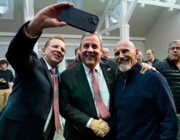 Former New Jersey Gov. Chris Christie, center, poses for a selfie after a town hall style meeting at New England College