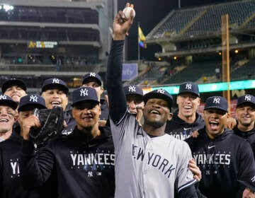 New York Yankees pitcher Domingo Germán, center, poses for a photograph with the team after his perfect game against the Oakland Athletics during a baseball game in Oakland, Calif., Wednesday, June 28, 2023.