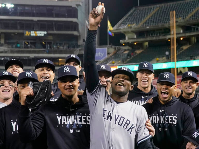 New York Yankees pitcher Domingo Germán, center, poses for a photograph with the team after his perfect game against the Oakland Athletics during a baseball game in Oakland, Calif., Wednesday, June 28, 2023.