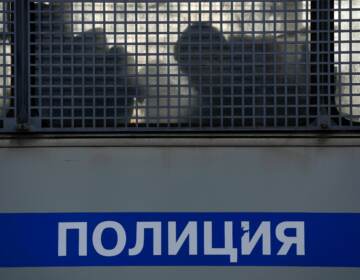 Silhouettes of detained people are seen in a police truck near the Moscow City Court during the trial of a Russian opposition leader in Moscow on February 2, 2021.