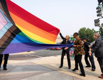 Energy Secretary Jennifer Granholm, center, helps raise a Pride flag outside of the Department of Energy as the Biden administration celebrates Pride Month.