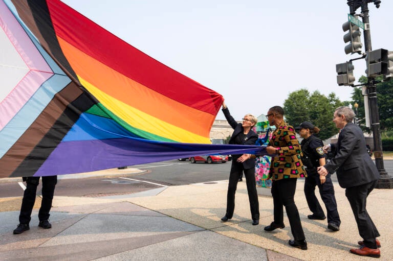 Energy Secretary Jennifer Granholm, center, helps raise a Pride flag outside of the Department of Energy as the Biden administration celebrates Pride Month.