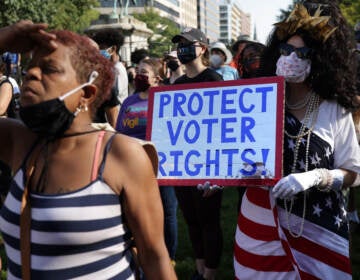 A demonstrator holds a sign saying 