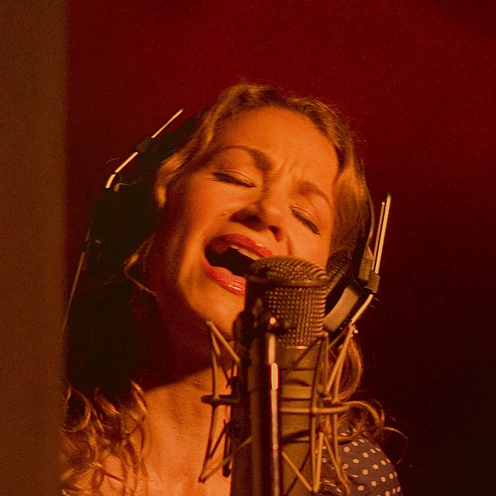 Joan Osborne sings into a microphone.