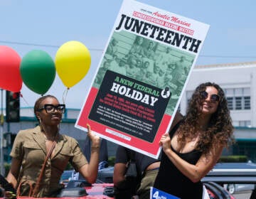 People holding up a sign for Juneteenth