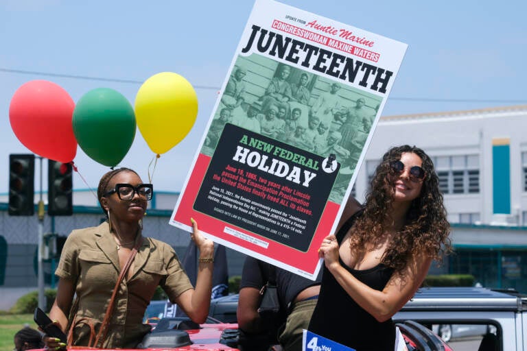 People holding up a sign for Juneteenth